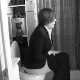 An attractive girl with short hair is recorded taking a piss while sitting on a toilet after she arrives home from work. About 2.5 minutes.